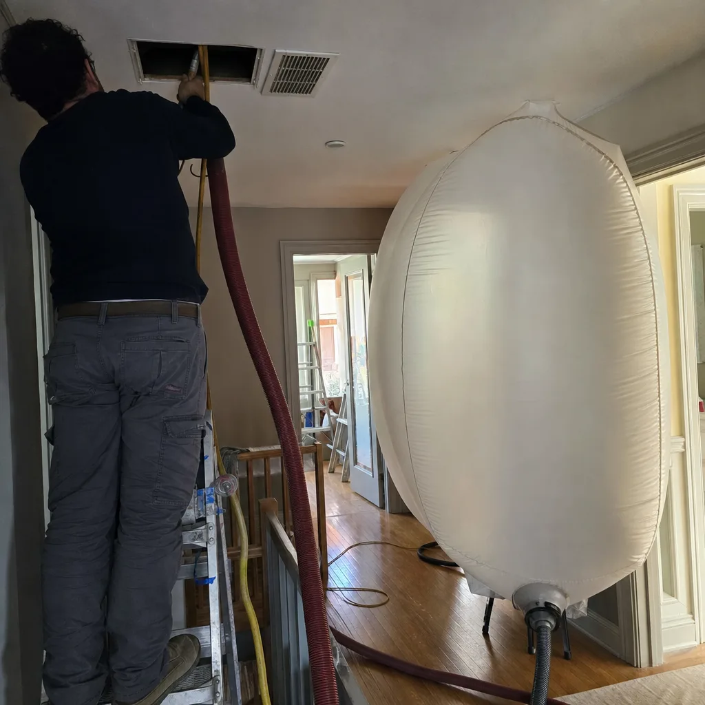 Technician performing professional residential air duct cleaning service